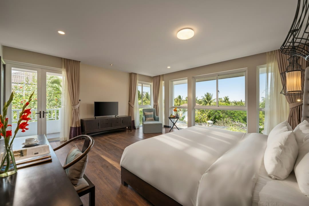 Master bedroom with ocean view, natural wood furniture, and warm sunlight