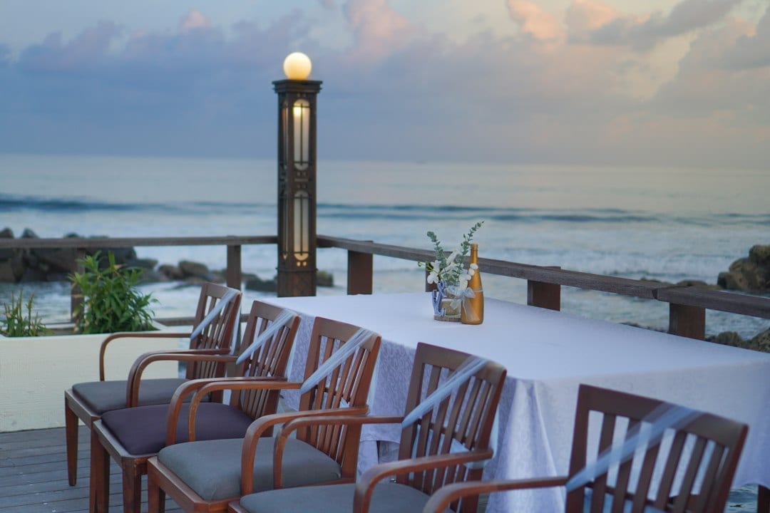 Outdoor dining area on the beach at sunset with lantern lights